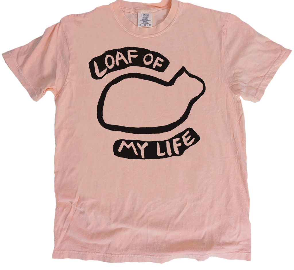Pink t-shirt with black graphic and text 'Loaf of My Life' on a white background