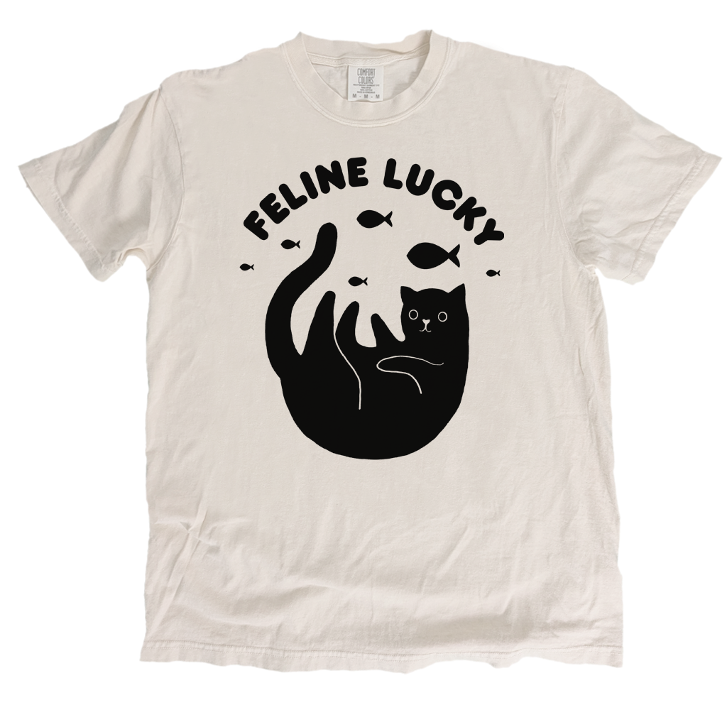 White t-shirt with black cat graphic and 'Feline Lucky' text on a white background